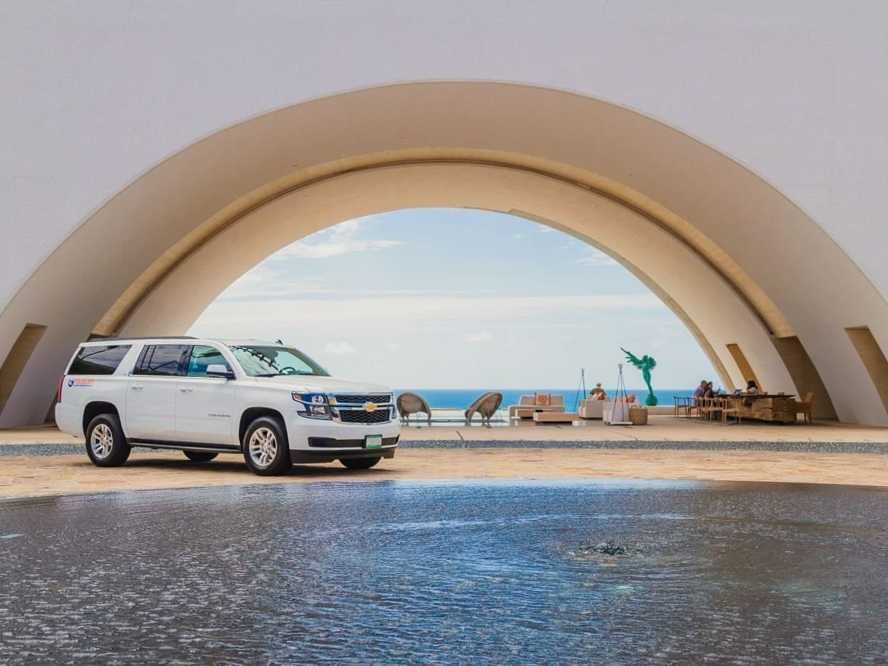 A car parked near a curved overhang by the sea at Los Cabos