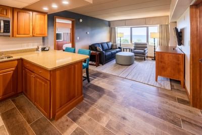 TV lounge with plush seating by the window and a kitchenette in the Lake View Suite at The Boulevard Inn & Bistro