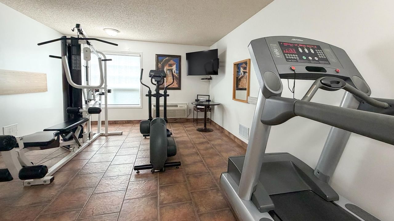 fitness room with treadmill, exercise bike and workout equipment at Coast Whitecourt Hotel