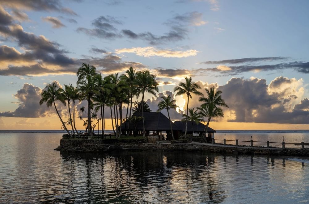 Wicked Walu by a quiet sea under a golden sunset near tropical palms at Warwick Fiji Resort and Spa