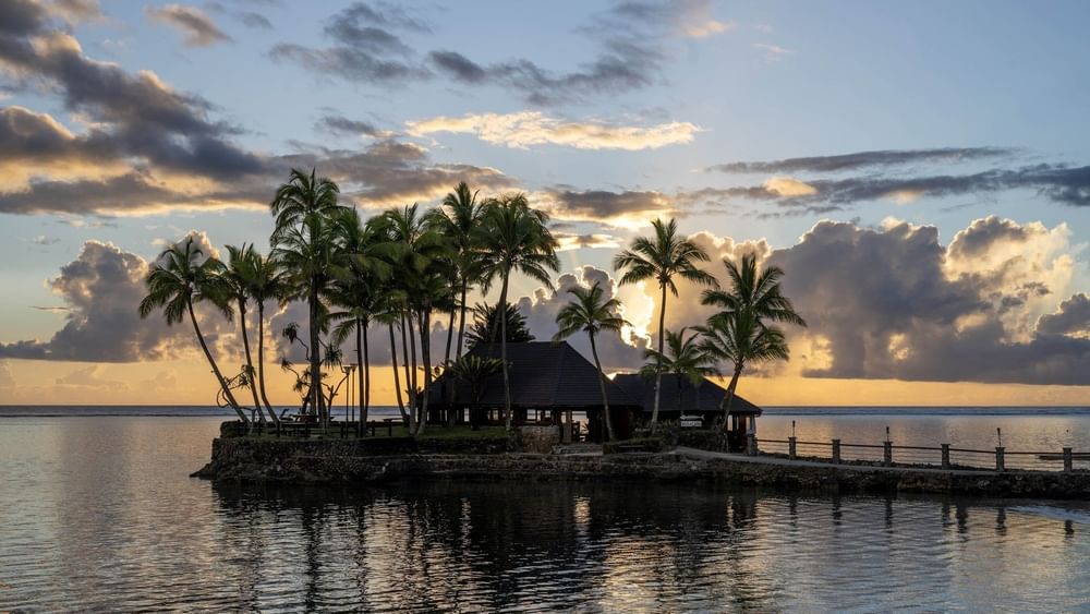 Wicked Walu by a quiet sea under a golden sunset near tropical palms at Warwick Fiji Resort and Spa