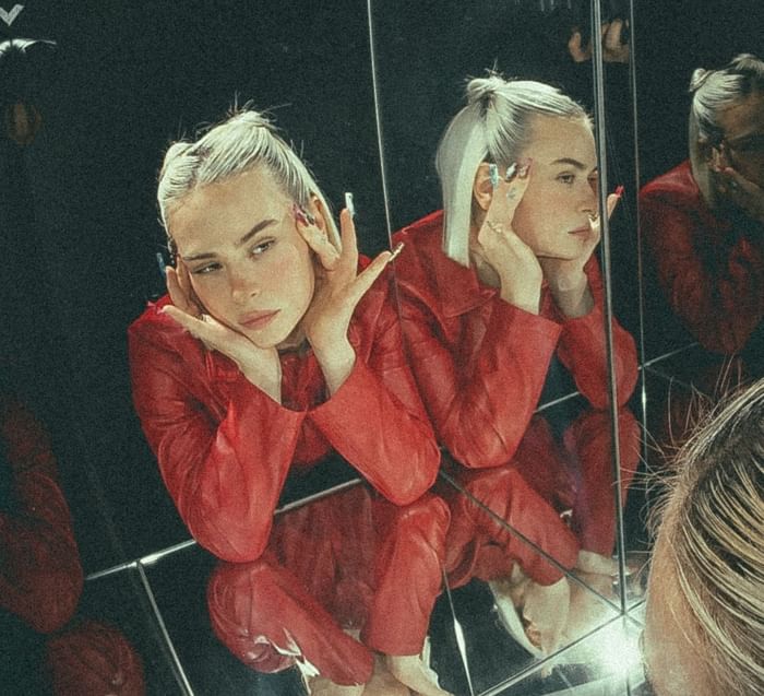 Mathea posing among mirrored reflections, creating a captivating and layered visual effect at Hotel Motto Vienna