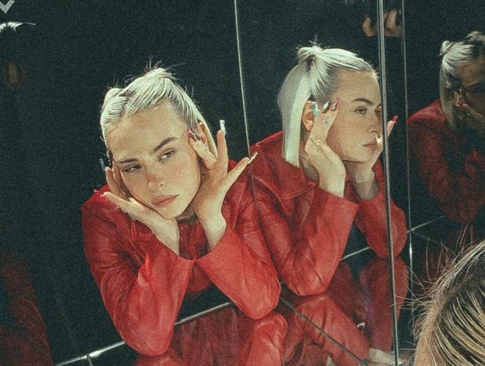 Mathea posing among mirrored reflections, creating a captivating and layered visual effect at Hotel Motto Vienna