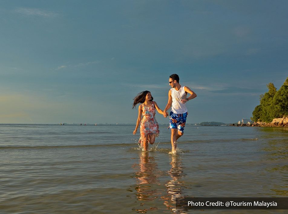 Couple running in the seawater on the beach - Lexis Hibiscus