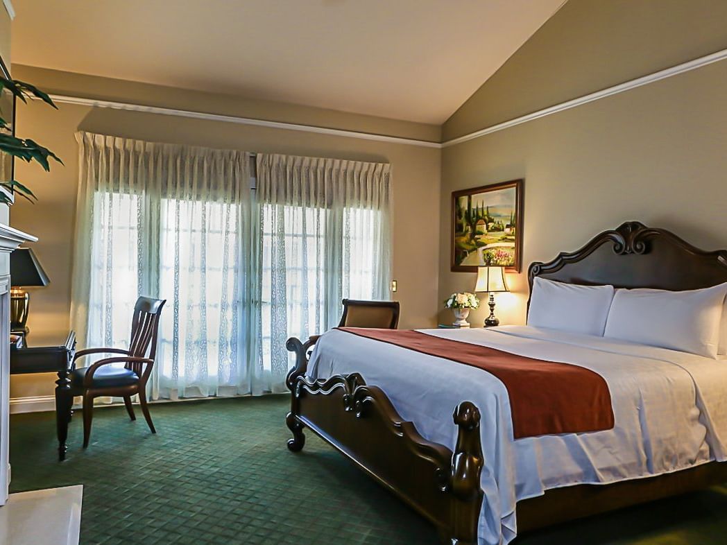 a bed, chair, and a desk in a hotel room