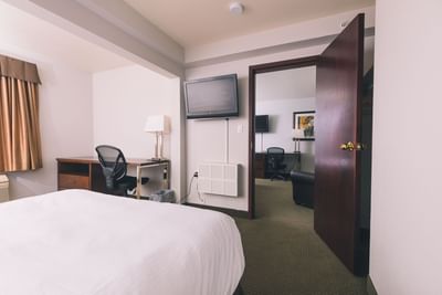 TV & work desk facing double beds in Deluxe Family Suite at Service Plus Inns & Suites