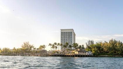 Waterfront view of Warwick Paradise Island hotel with palm trees and a clear sky