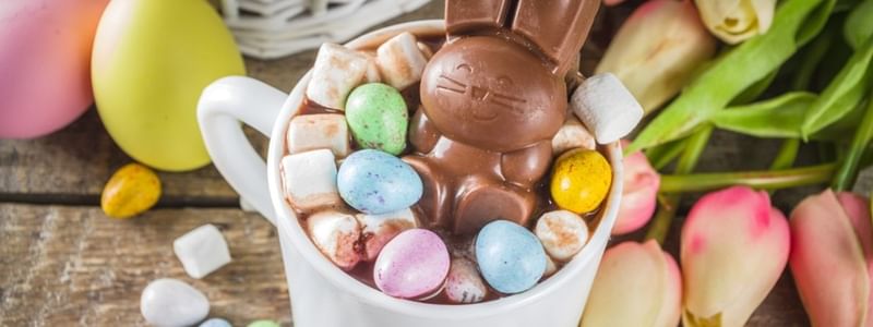 Chocolate bunny in a cup of hot cocoa with marshmallows and candies for Easter School Holidays Activities.