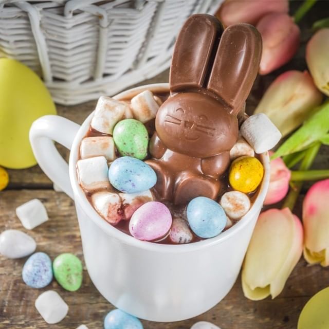 Chocolate bunny in a cup of hot cocoa with marshmallows and candies for Easter School Holidays Activities.