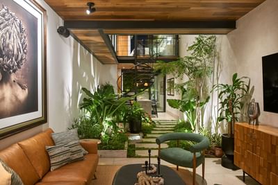 Cozy living area with a sofa, and an indoor courtyard with a spiral staircase in Casa Cielo at Singular Signature Residences