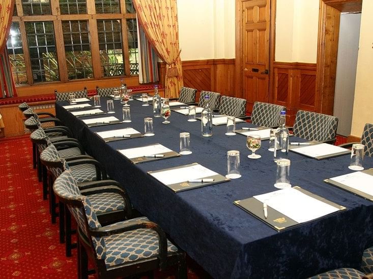 The Samuel Pepys Room at Marygreen Manor, featuring a large dark blue table and comfy patterned chairs