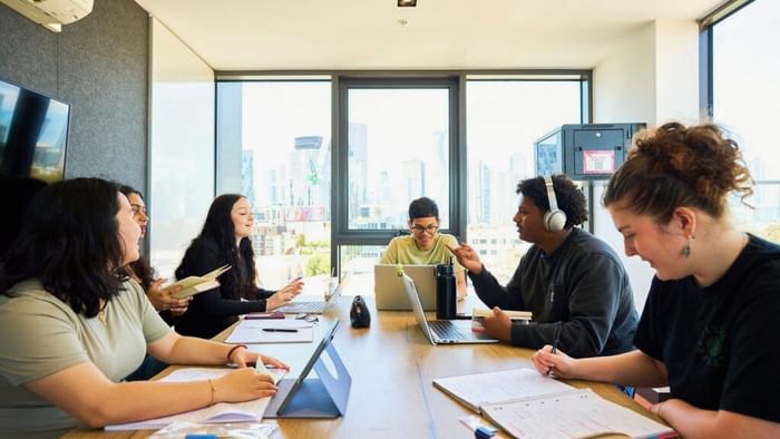 Students collaborating with laptops and notebooks in study rooms at UniLodge Royal Melbourne in North Melbourne.
