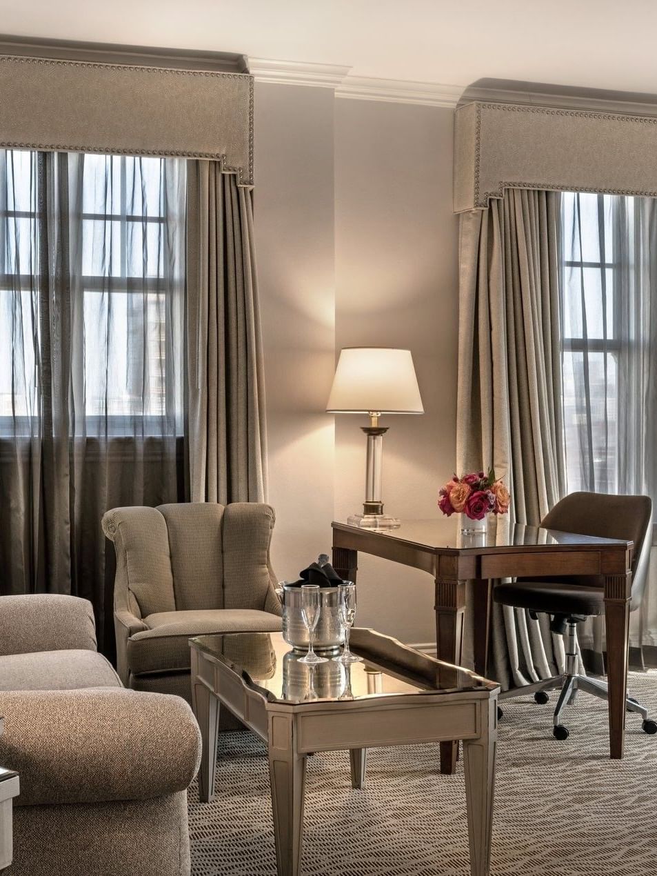 Elegant Corner King room with couch, desk, and large windows at Warwick Melrose Dallas.