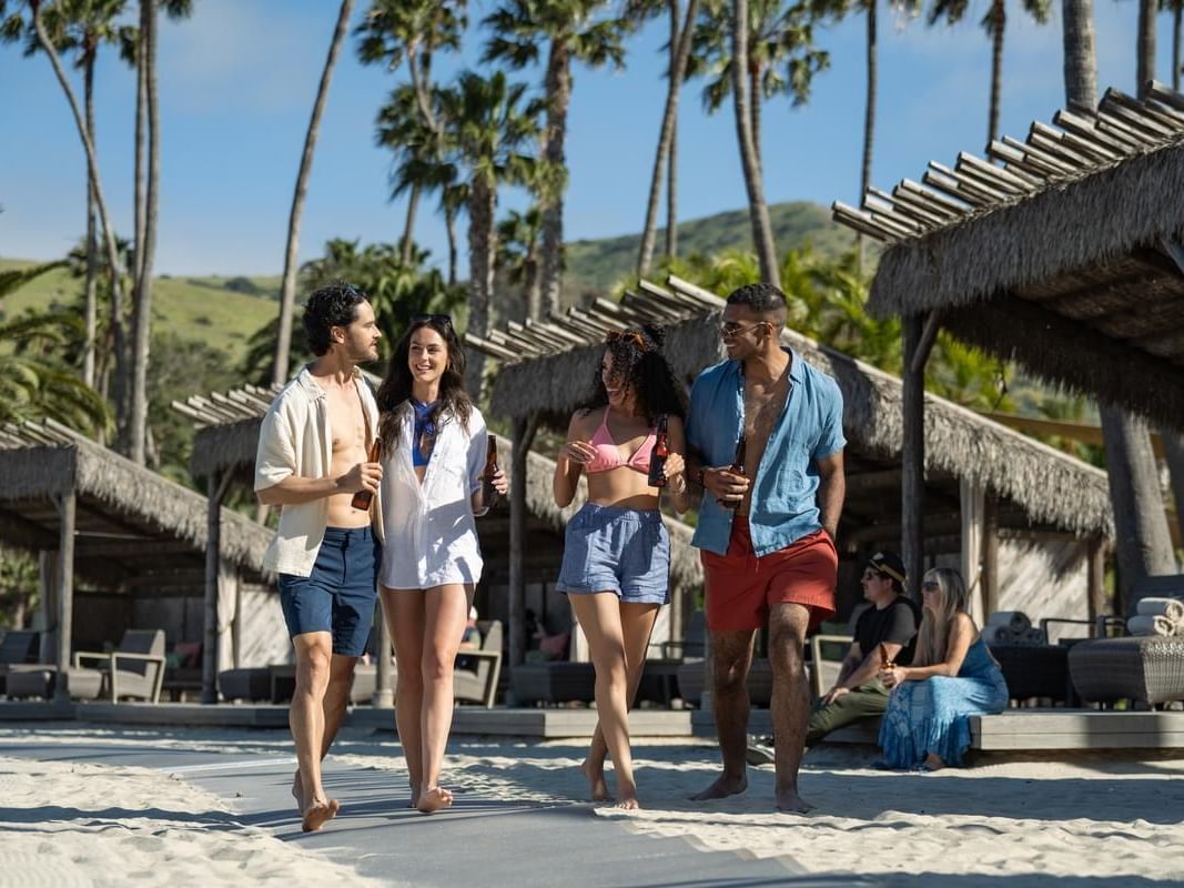 Two couples walking on a sandy beach near Catalina Island Company