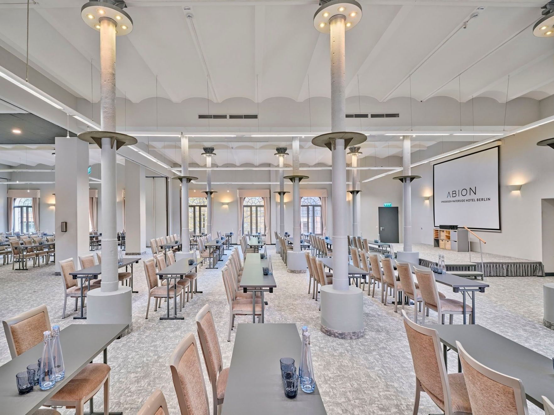 Spacious conference room with arranged tables and chairs at Abion Spreebogen Waterside Hotel Berlin.