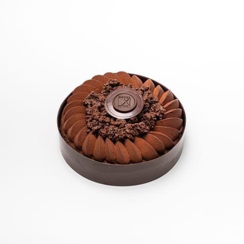 Gâteau au chocolat avec logo sur le dessus à l'hôtel X Offres de Toronto