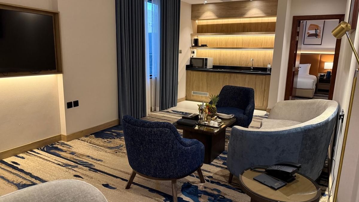 TV lounge with couches and a coffee table beside the kitchenette in One Bedroom Suite at Warwick Jeddah Hotel & Spa