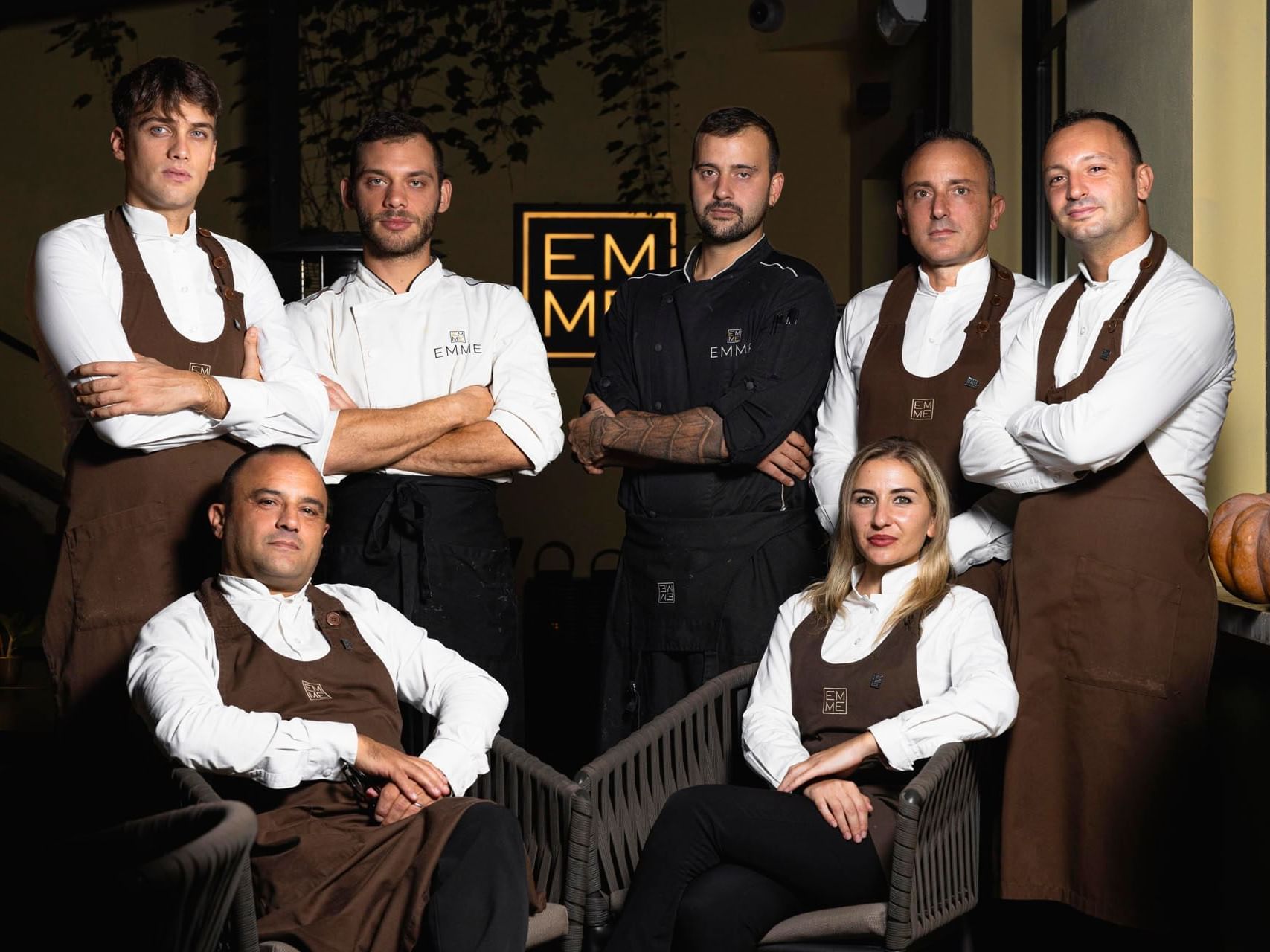 A group of chefs posing for a photo at EMME Restaurant