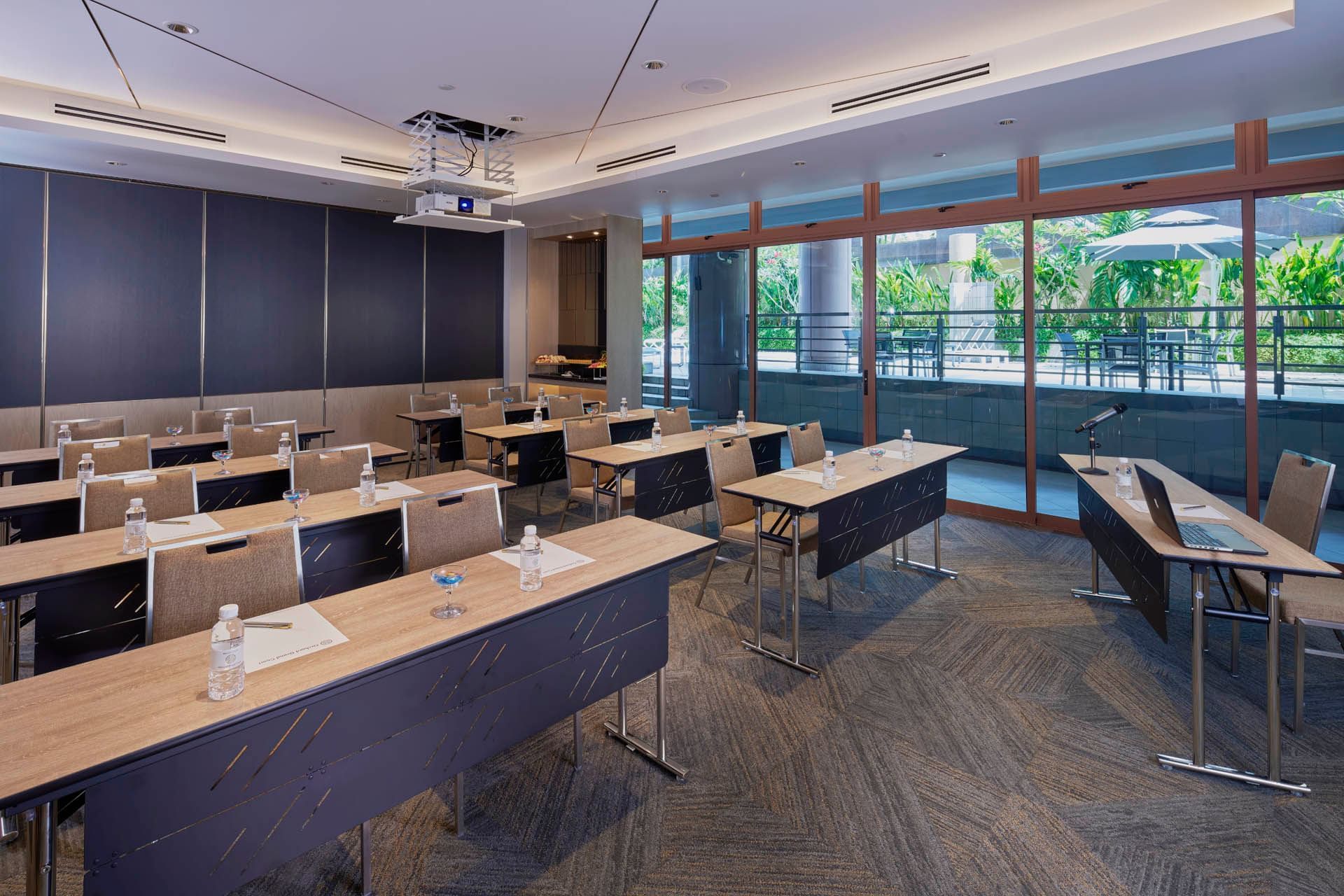 Stylish meeting room with a classroom setup and a projector, offering a green view at Orchard Grand Court