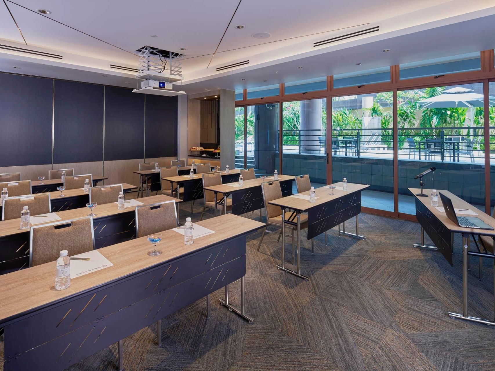 Stylish meeting room with a classroom setup and a projector, offering a green view at Orchard Grand Court