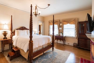 TV & nightstand by the bed in Grand Bedroom with wooden floors at Mt Ada