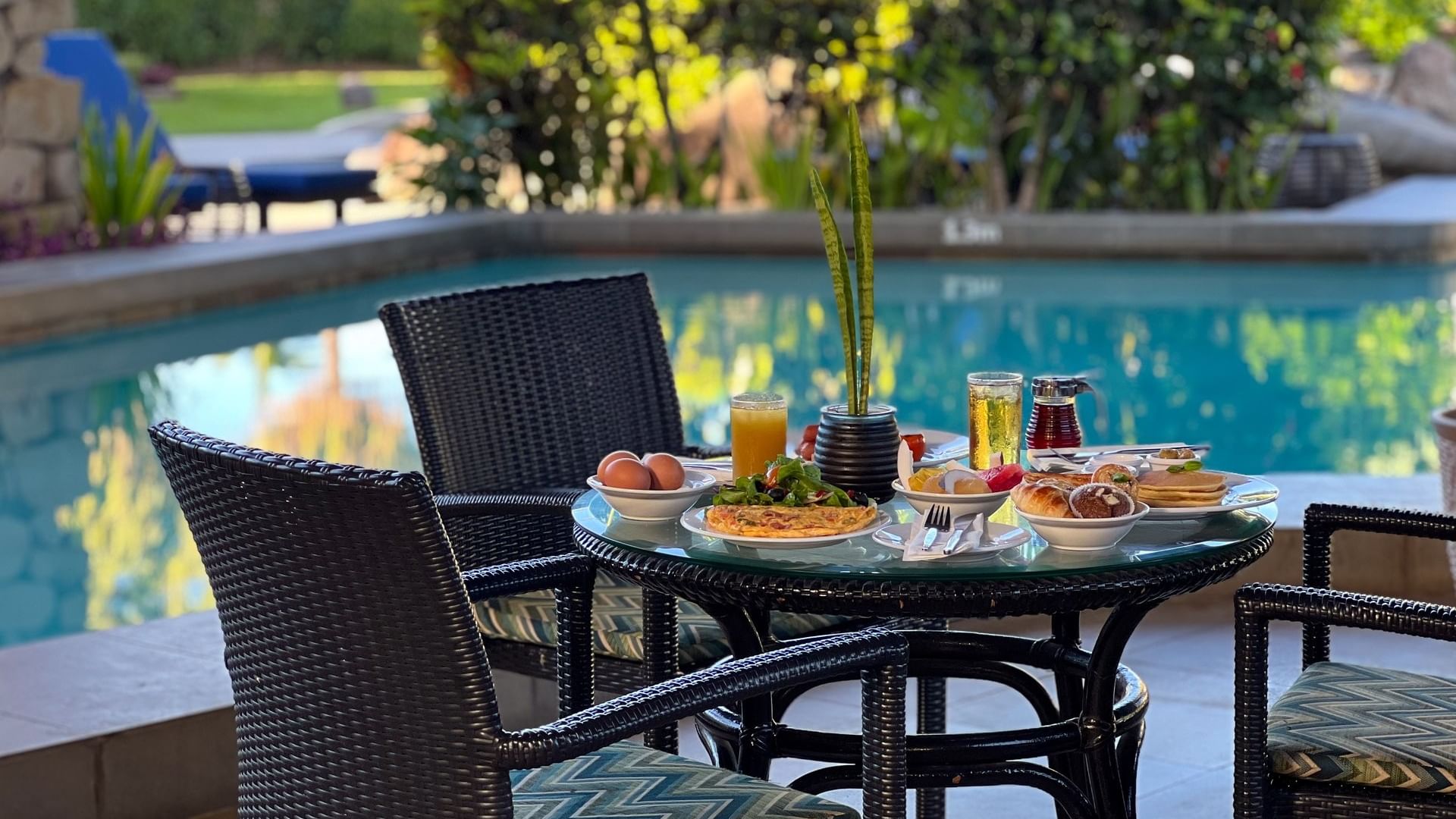 Table with breakfast food by the pool at KanaVata Restaurant in Nadi at Tokatoka Resort - Fiji International Airport