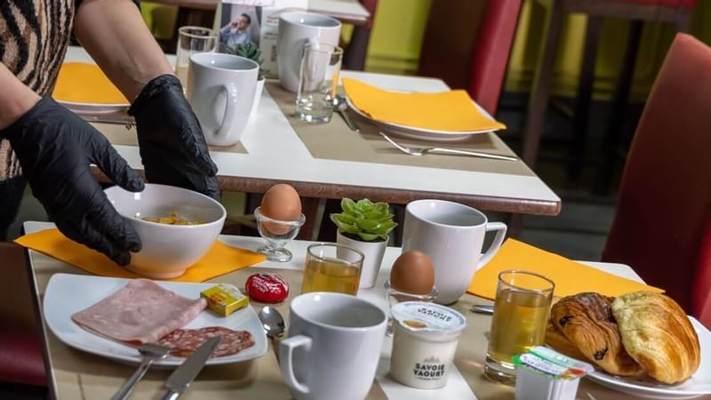Close-up of arranging breakfast table at Originals Hotel