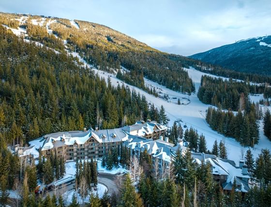 Aerial view of hotel surrounded by snowy mountains at Blackcomb Springs Suites