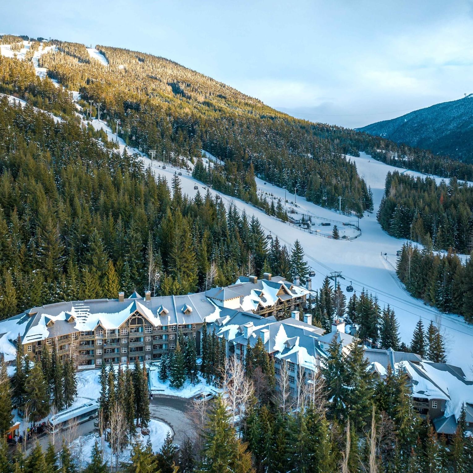 Aerial view of Blackcomb Springs Suites with mountains under the blue sky