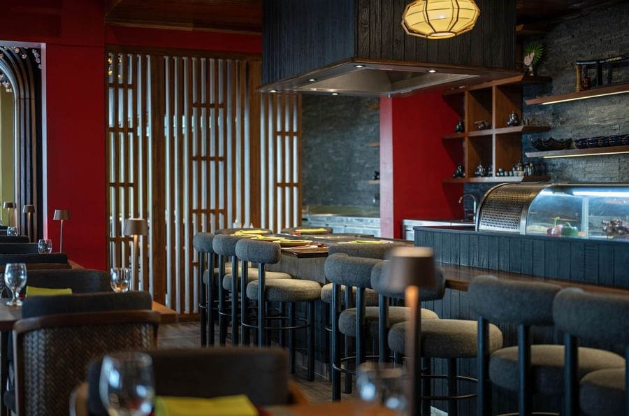 Grey bar stools by a wooden counter under a black range hood in Sazanami at Warwick Fiji Resort and Spa