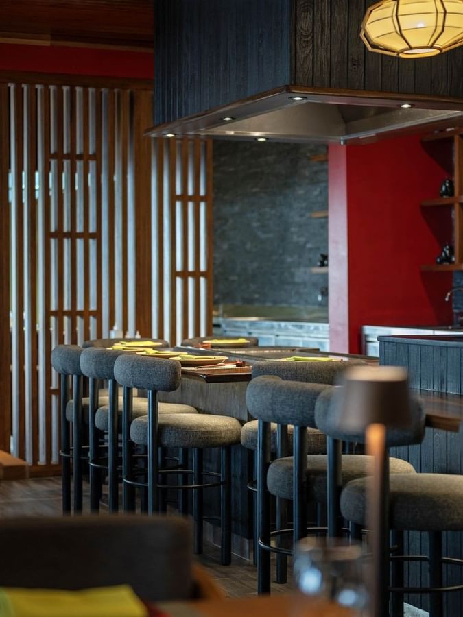 Grey bar stools by a wooden counter under a black range hood in Sazanami at Warwick Fiji Resort and Spa