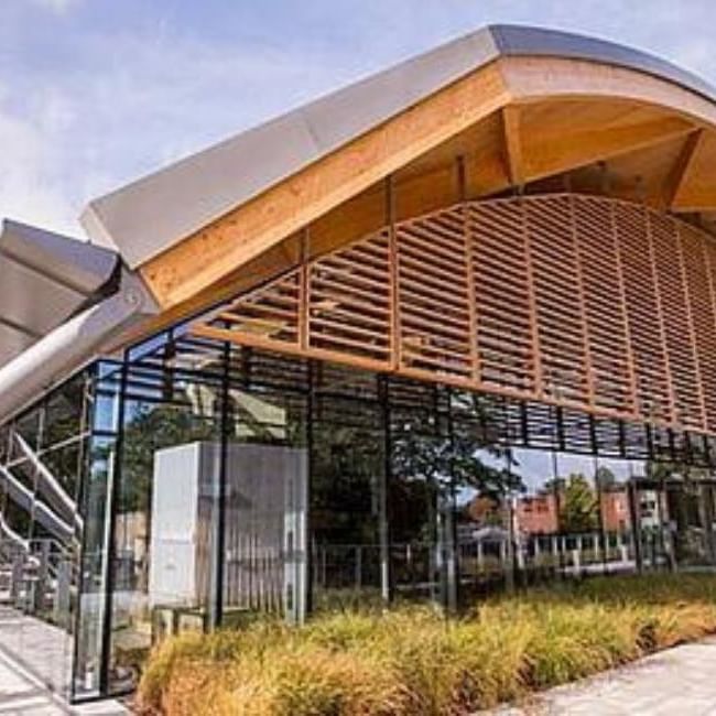 Modern curved timber roof building with glass walls and wooden slat cladding at The Living Planet Centre in Woking