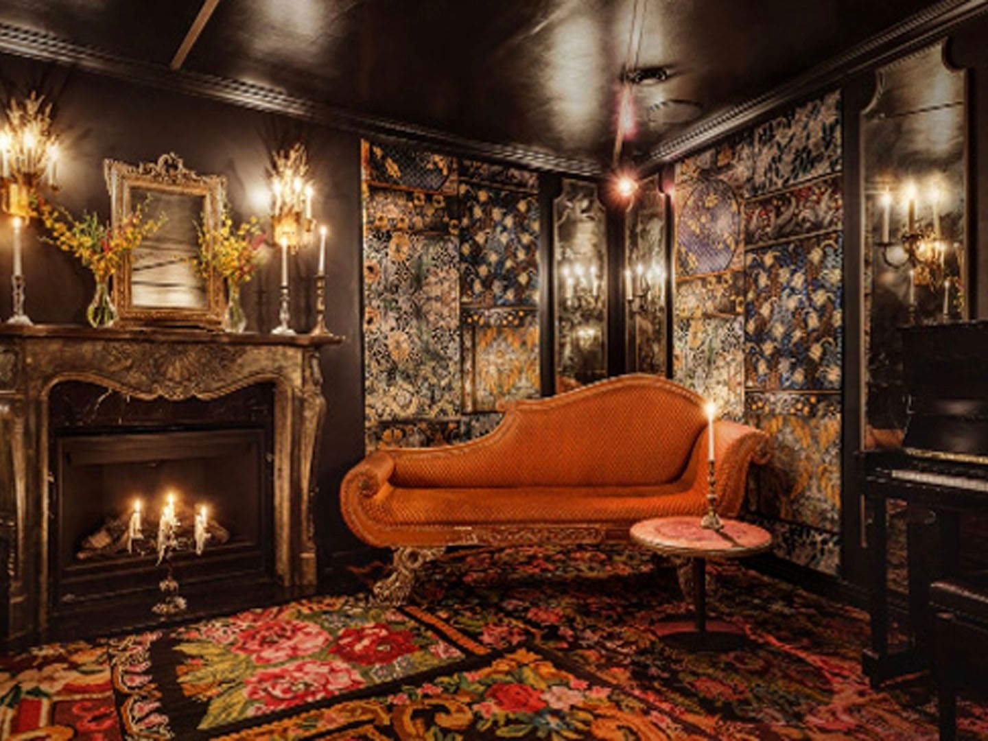 The Wiggle Room with an orange chaise lounge by an ornate fireplace, and a floral-patterned carpet at Petit Ermitage