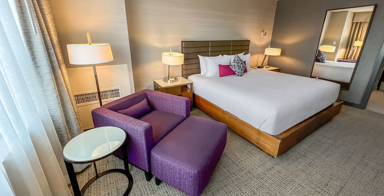 Hotel washroom with bed, mirror, couch, and desk