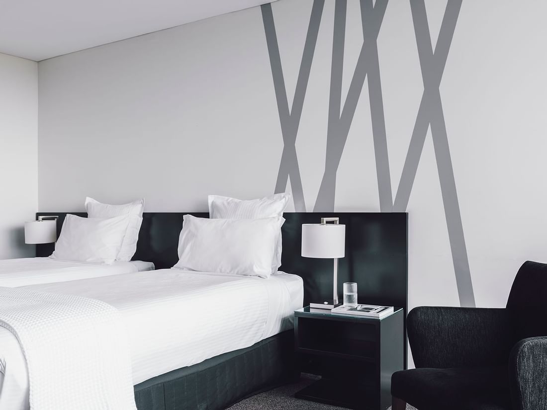 Comfy lounge by the beds in Studio Room with 2 Single Beds at Quay West Suites Melbourne