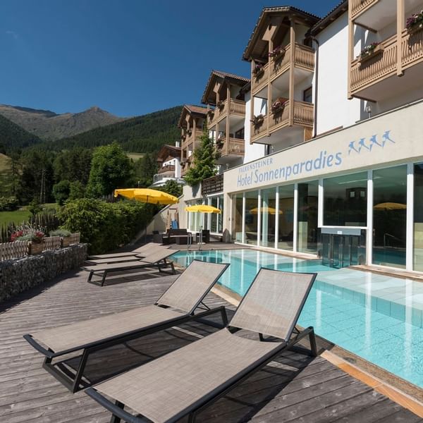 Sunbeds by the outdoor pool at Falkensteiner Hotels