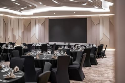 Banquet tables arranged in the carpeted Meeting Room at Amora Hotel