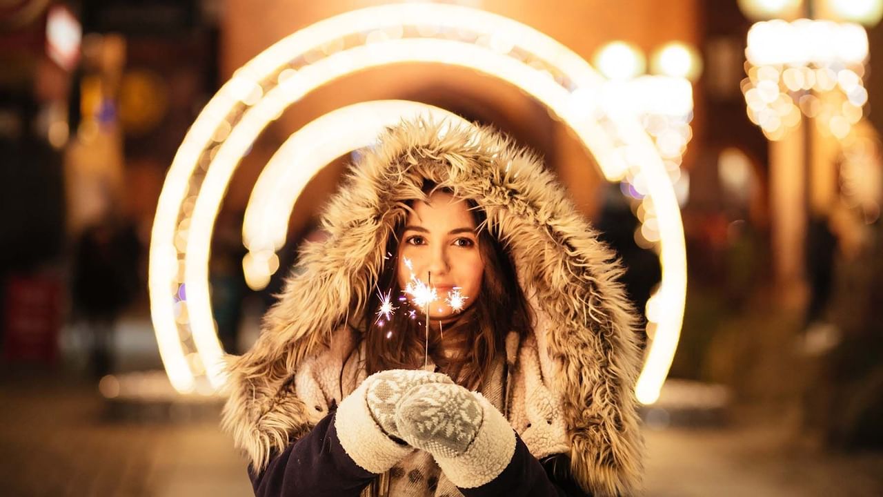 Woman in winter clothes holding a sparkler