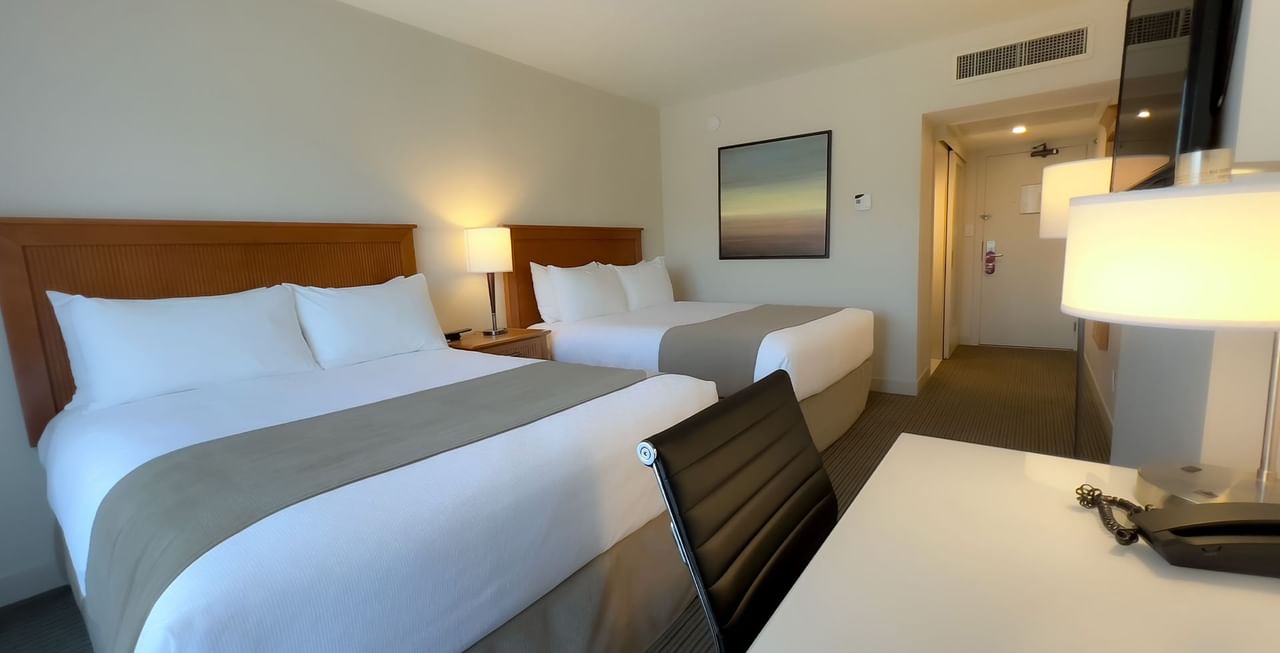 Hotel room with two queen beds, TV, work desk and chair