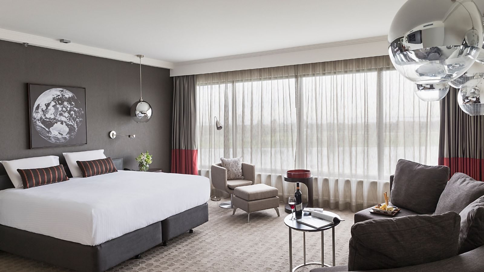 King bed and seating in Deluxe Lakeview Room at Pullman Albert Park