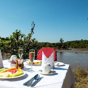 A Dining Table Infront Of A Lake At Mara Serena Safari Lodge