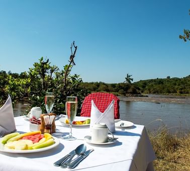 A Dining Table Infront Of A Lake At Mara Serena Safari Lodge