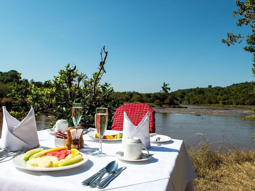 A Dining Table Infront Of A Lake At Mara Serena Safari Lodge
