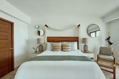 An elegant luxury resort bedroom with double beds, premium linens, and a bright tropical ambiance.