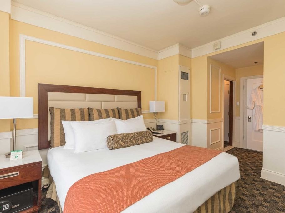 Cozy hotel room with a comfortable bed, nightstands, and a bright yellow decor.