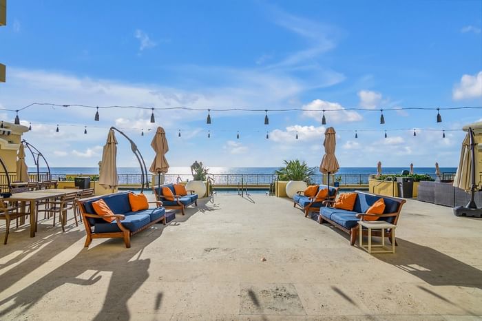Blue sofas & orange pillows on spacious stone Ocean View Terrace in event space Fort Lauderdale at The Atlantic Hotel & Spa