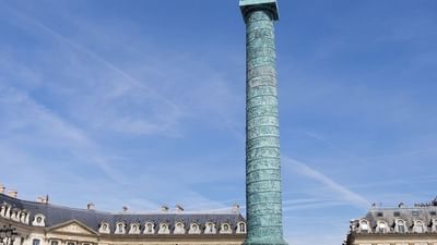 Vendôme Column standing tall by classic stone buildings under a bright blue sky near Hotel Westminster Paris