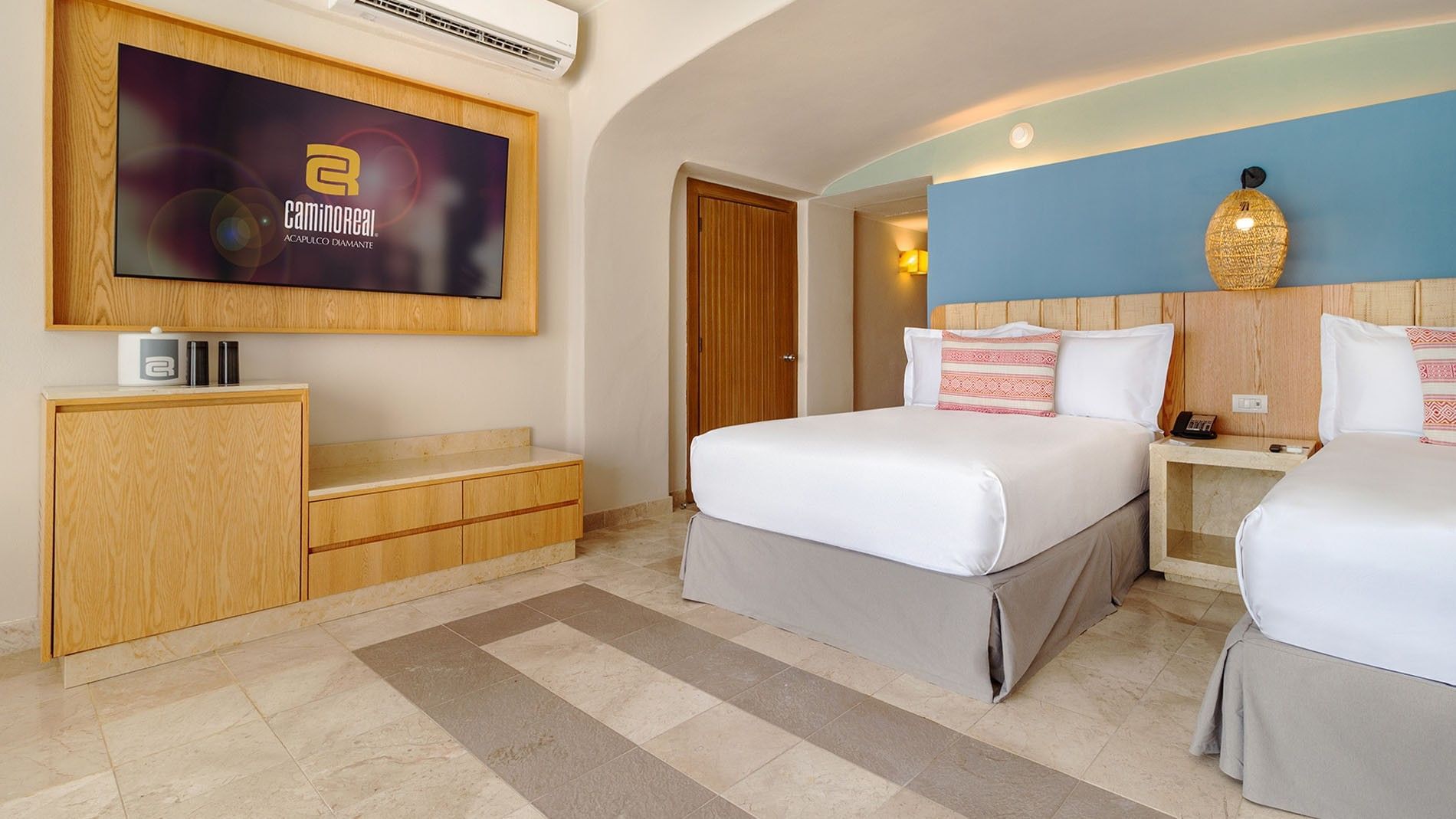 Wall-mounted TV and wooden accents by the bed in Ocean View Two Double Deluxe Superior Room at Camino Real Acapulco Diamante