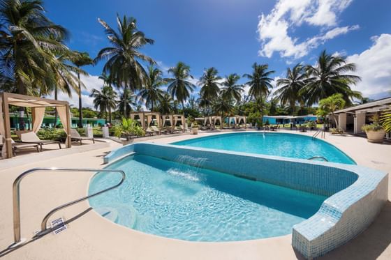 Outdoor pool surrounded by trees on a sunny day at All Seasons Resort Europa