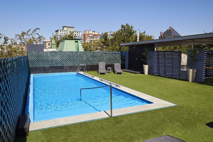 Outdoor swimming pool with a lounge at Hotel Torremayor Lyon
